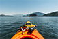 Scenic view of a kayak on the water with towering mountains in the background. Vancouver Water Adventures.