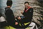 Two men in wet suits riding a jet ski on the water.