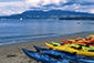 A row of kayaks lined up on the sandy beach, ready for adventure. Vancouver Water Adventures